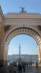 Plaza with statue column viewed through archway