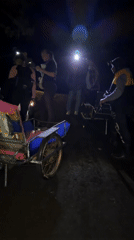 Night gathering around trishaw and cart in Indonesia