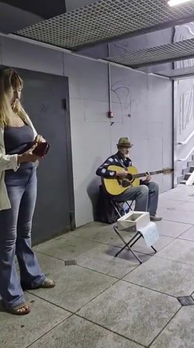 Wet streets and a busker in a Vladivostok underpass