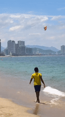Quiet morning on Nha Trang beach, kiteboarder out on the water