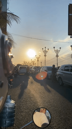 Motorcycle rider documents morning street scenes in Madiun, Indonesia