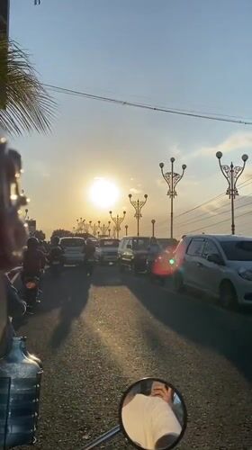 Motorcycle rider documents morning street scenes in Madiun, Indonesia