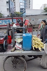 Street vendor operates sugarcane juice cart in Dhaka