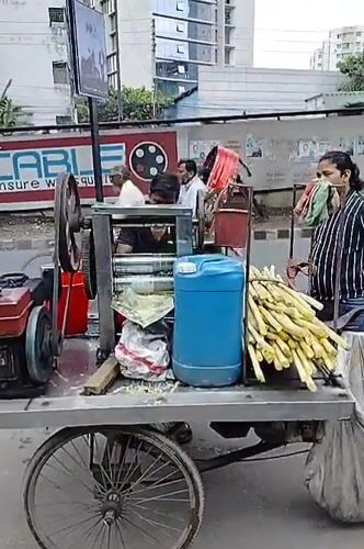 Street vendor operates sugarcane juice cart in Dhaka