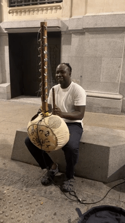 Kora player busking outside an ornate Madrid building