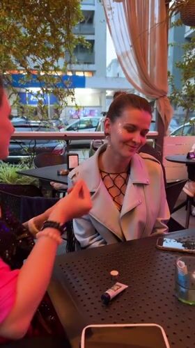 Women apply makeup, socialize at outdoor bar in Montenegro