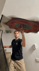 Man holds tie-dye fabric in Tel Aviv stairwell