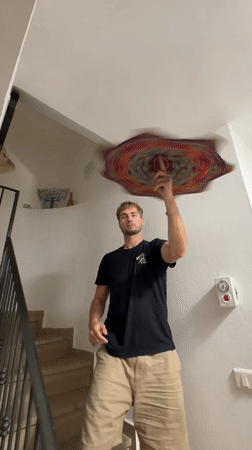 Man holds tie-dye fabric in Tel Aviv stairwell
