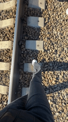 Person walks railroad tracks by water in Toksovo Russia