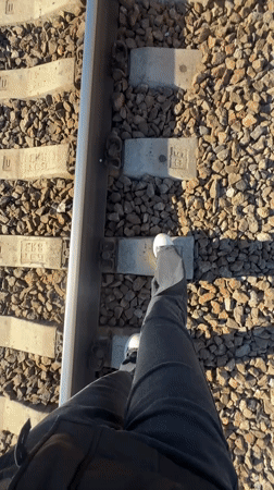 Person walks railroad tracks by water in Toksovo Russia