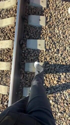 Person walks railroad tracks by water in Toksovo Russia