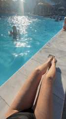Person relaxes poolside on sunny afternoon