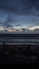 Twilight beach scene captured showing gentle waves, colorful sky