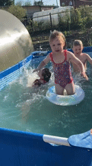 Children swim, woman travels in Chaikovsky during spring afternoon