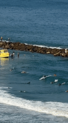 Surfers and jet skis share Netanya's coastline on a summer morning