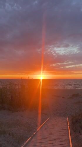 Sunset observed over Lilaste beach with wooden boardwalk