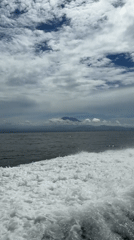 Boat travels toward mountainous island in Indonesian waters