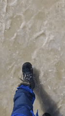 Person walks through slushy ice in waterproof boots, Russia