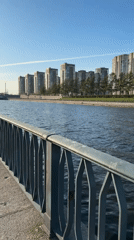 Woman walks along sunny waterside walkway in Saint Petersburg