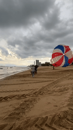 Parasailing and jet skis on a cloudy Pattaya morning