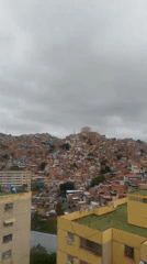Aerial views document Caracas neighborhoods under cloudy skies