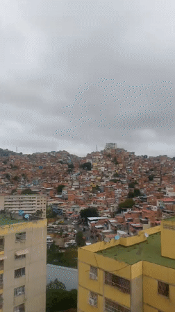 Aerial views document Caracas neighborhoods under cloudy skies