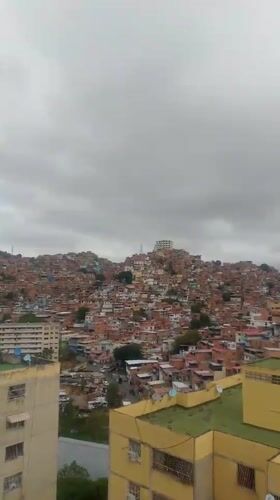Aerial views document Caracas neighborhoods under cloudy skies