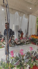 Tented community gathering with floral decor and donation setup