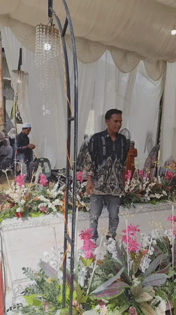 Tented community gathering with floral decor and donation setup