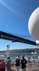 Ship passing under Lisbon's iconic suspension bridge
