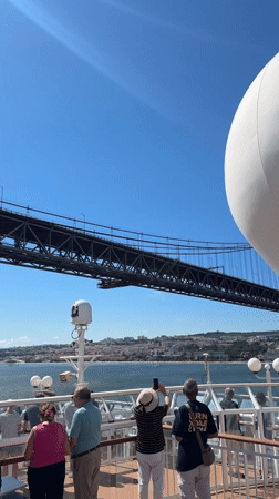 Ship passing under Lisbon's iconic suspension bridge