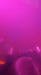 Nightclub crowd dances under colorful lights in Paris