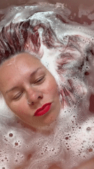 Woman with distinctive hair observed bathing in reddish water