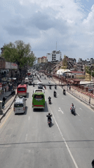 Religious procession with decorated trucks moves through busy Kathmandu streets