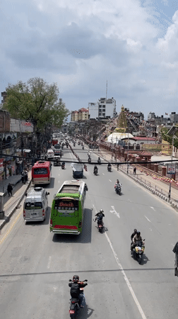 Religious procession with decorated trucks moves through busy Kathmandu streets