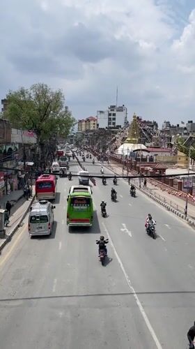 Religious procession with decorated trucks moves through busy Kathmandu streets