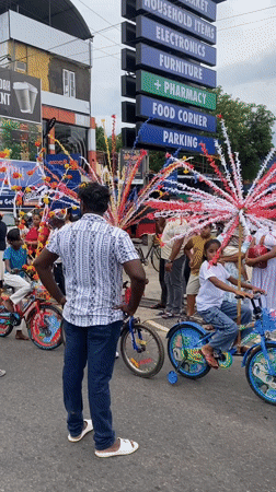 Children ride decorated bicycles through Galle streets