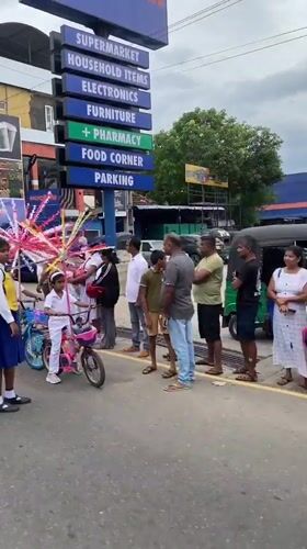 Children ride decorated bicycles through Galle streets