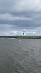 Kitesurfers enjoy choppy waters near Chaikovsky under cloudy skies