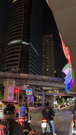 Bangkok traffic stops at red light near modern building