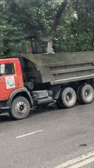 Dump truck with raised bed blocks wet Dushanbe street