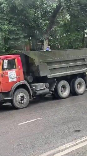 Dump truck with raised bed blocks wet Dushanbe street