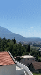 Man enjoys morning orange juice on Montenegro balcony overlooking coast