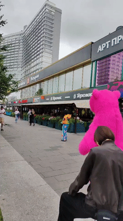 Giant pink inflatable bear roams a Moscow sidewalk