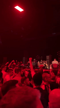 DJ performs at nightclub as crowd records on phones