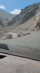 Vehicle travels mountain road near Sarvoda, Tajikistan