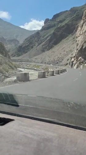 Vehicle travels mountain road near Sarvoda, Tajikistan