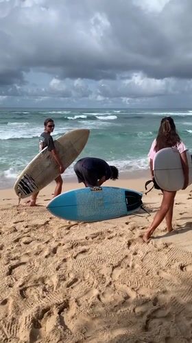Early morning surfing session continues despite stormy skies