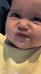 Infant in yellow bib photographed mid-meal in North Kuta