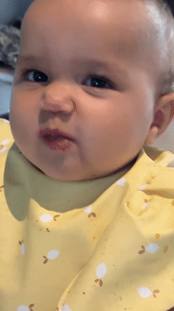 Infant in yellow bib photographed mid-meal in North Kuta